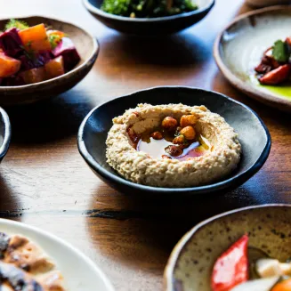 Butcher & Bee signature dishes Whipped Feta with Fermented Honey, Bacon-wrapped Dates, Crispy Rice, Shawarma